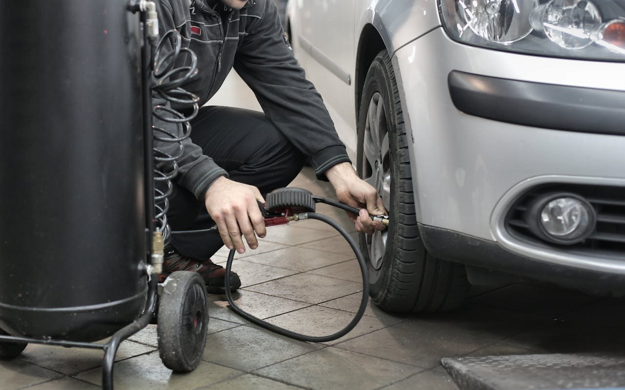 Mastering the First Impression: Your intriguing post title goes here Mechanic inspecting and adjusting tire pressure in an auto repair shop.